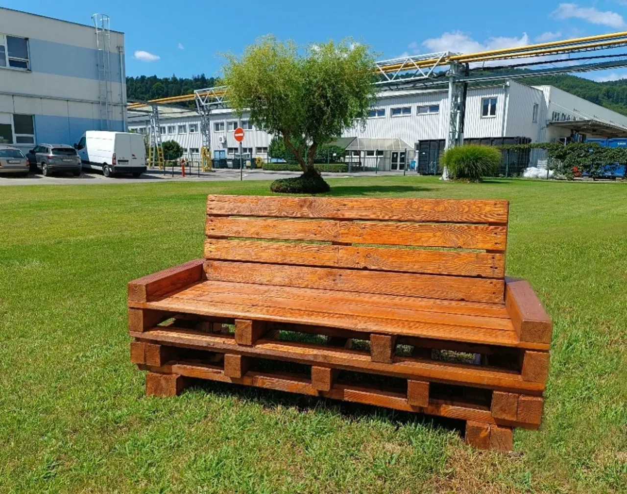 Hölzerne Bank auf Gras, blauer Himmel